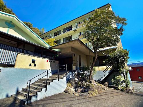 a building with stairs and a tree in front of it at Honjin in Izunokuni