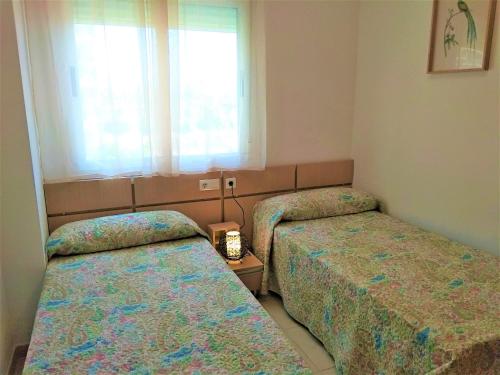 a room with two beds and a window at ACV - Vistamar III-1ª línea planta 2 Frontal in Oropesa del Mar
