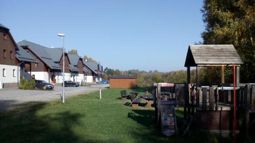 a park with a playground in a residential neighborhood at Apartmán PECKA - Nová Pec in Nová Pec