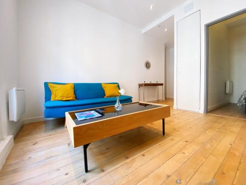 a living room with a blue couch and a coffee table at HYPERCENTRE 2 appartement climatisé in Toulouse