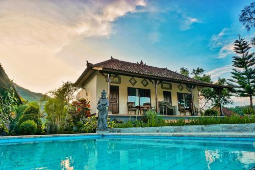 a house with a swimming pool in front of a house at Mapa Lake View Bungalow in Kintamani