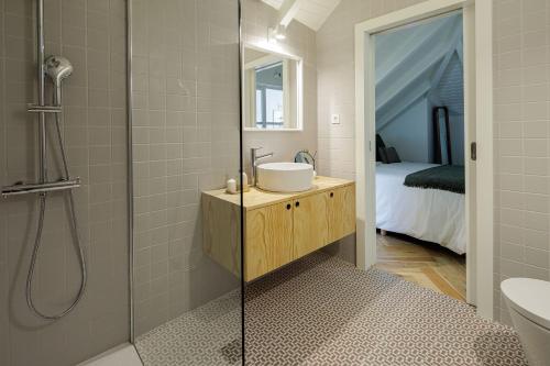 Carvoeiro Boutique Apartments في أمارانتي: حمام مع دش مع حوض ومرحاض