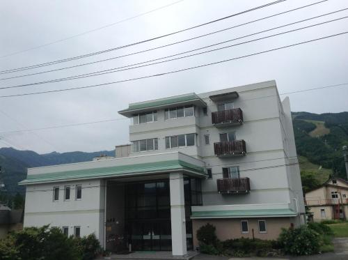 a white building with balconies on it at Happokan in Hakuba