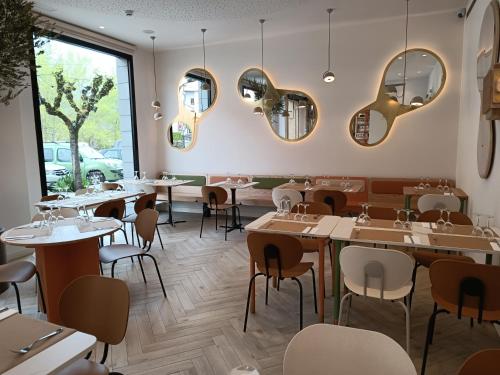 un restaurante con mesas, sillas y espejos en Apartahotel Dos Ríos Ainsa, en Aínsa