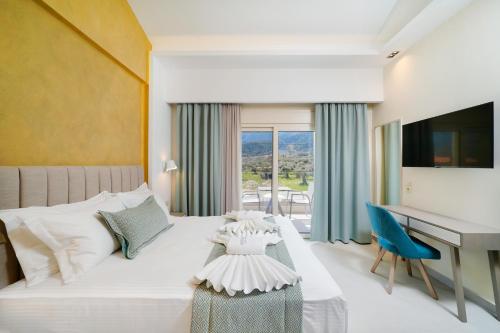 a bedroom with a bed with a desk and a computer at Supreme Luxury Suites in Skala Potamias