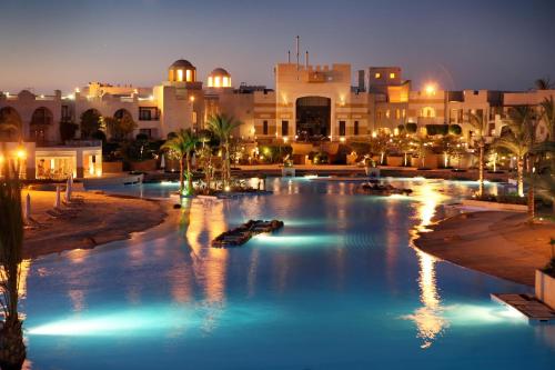a large swimming pool in a city at night at Pickalbatros The Palace Port Ghalib in Port Ghalib