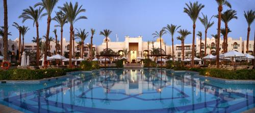 a large swimming pool in a resort with palm trees at Pickalbatros The Palace Port Ghalib in Port Ghalib