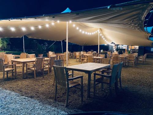 a group of tables and chairs under a tent at The Elm 