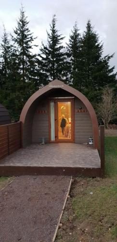 a small house with an arch around the door at Missin' Link Glamping in West Hoathley