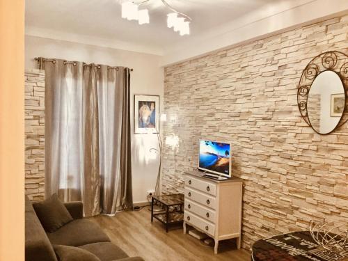 un salon avec un mur en pierre dans l'établissement Studio Bel Air FSHH, à Nice