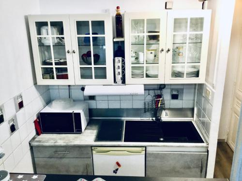 une cuisine avec des armoires blanches et un évier dans l'établissement Studio Bel Air FSHH, à Nice