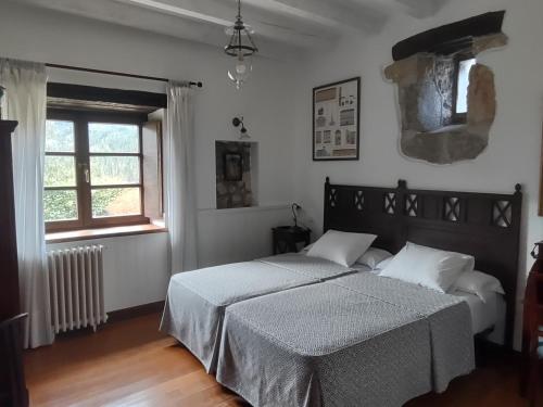 sypialnia z łóżkiem i oknem w obiekcie Hotel Rural Natxiondo w mieście Lekeitio