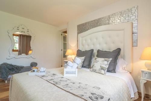 1 dormitorio con 1 cama blanca grande y espejo en Refugi De Les Aguiles, en Lloseta