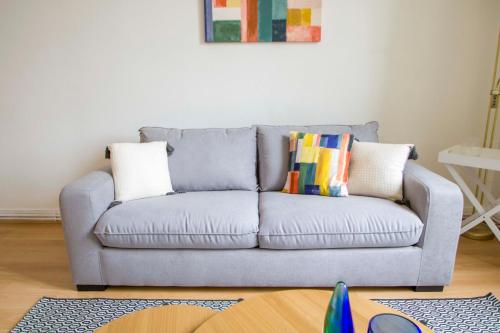 - un canapé bleu avec des oreillers dans le salon dans l'établissement Le Parc, à Thonon-les-Bains