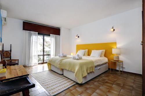 a bedroom with a large bed with a yellow headboard at La Casa de Manuel in Estepona
