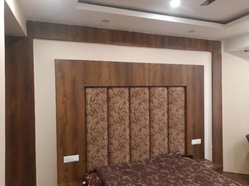 a bed in a room with a wooden wall at Hotel Zoon Dabb Srinagar airport kashmir in Srinagar