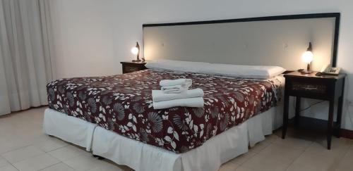 a hotel room with a bed with towels on it at Panacea Hotel in Villa General Belgrano
