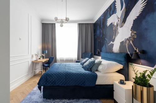 a bedroom with a bed with a blue wall at Sanhaus Apartments - Apartament Garda, 2 sypialnie, parking in Sopot