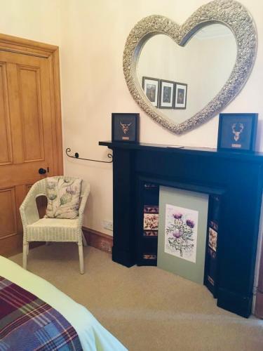 a room with a heart mirror and a chair at The Gables in Crail