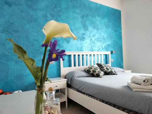 ラ・スペツィアにあるLevante Bluのベッドルーム1室(ベッド1台付)、紫の花の花瓶1枚