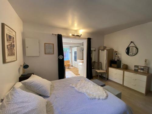 a bedroom with a large bed and a kitchen at Agréable studio proche StTropez Piscine et Tennis in Gassin