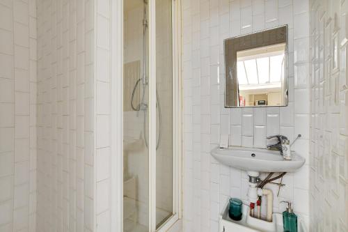 une salle de bain blanche avec un lavabo et un miroir dans l'établissement Cozy studio - 2P - Close to Sacré-Cœur, à Paris
