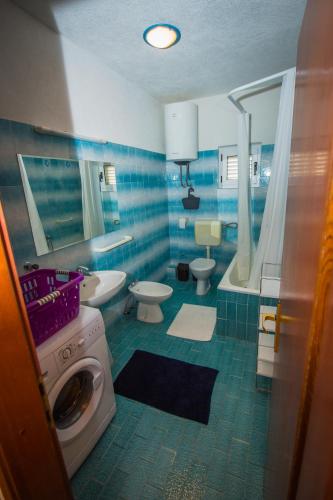 a bathroom with a sink and a washing machine at Villa Nedo in Baška Voda