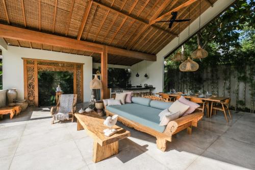 a patio with a blue couch and a table at Villa Kikaa Bingin in Uluwatu