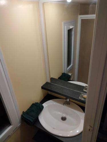 a bathroom with a white sink and a mirror at Mobile home Portiragnes in Portiragnes