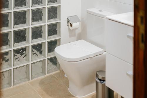 
a white toilet sitting in a bathroom next to a window at Atlantis Park Resort in Punta del Hidalgo
