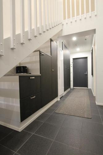 a hallway with a staircase with black cabinets at Hilmantori Apartments by Hiekka Booking in Kalajoki