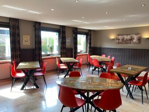 een restaurant met houten tafels en rode stoelen bij Hotel de Vaart in Damme