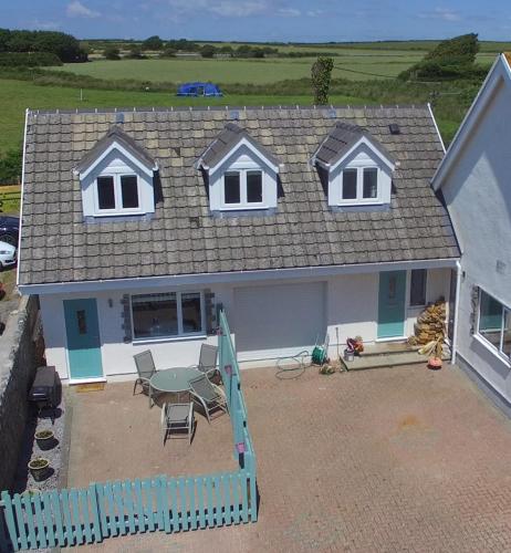a house with a patio and a table and chairs at Sea dream lodge -coastal location/sea views/self-contained in Southerndown