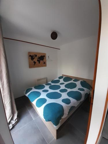 a small bedroom with a blue and white bed at Appartement au calme à Pernes 1 chambre in Pernes