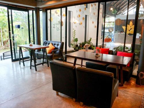 a restaurant with two tables and chairs and windows at Z&Z Resort in Rawai Beach