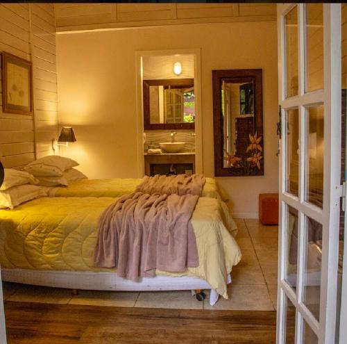 a bedroom with a bed with a sink and a mirror at Pousada das Gêmeas in Ilha do Mel
