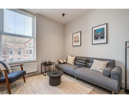 a living room with a couch and a window at Central Belfast Apartments: University Street in Belfast