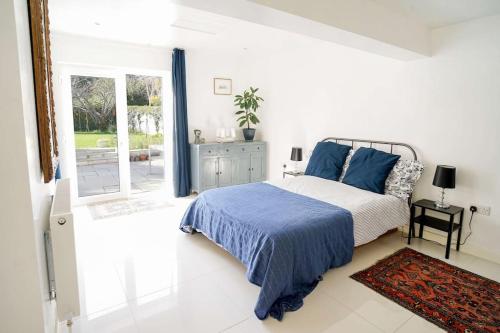 a bedroom with a bed and a sliding glass door at Seashells - Bembridge in Bembridge