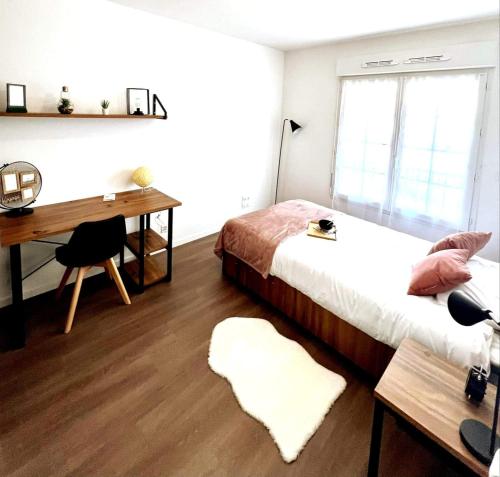 una camera da letto con un letto, una scrivania e una scrivania di Neoresid Paris-Gagny a Gagny