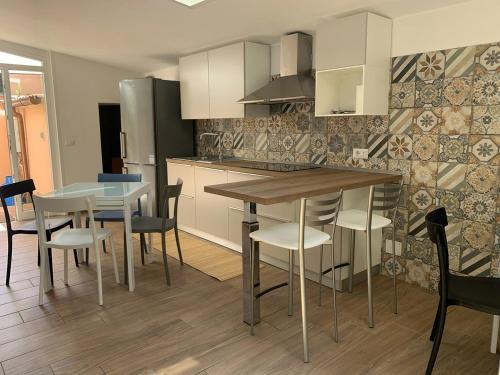 a kitchen with a table and some chairs and a counter at ComfortHouse Ladispoli in Ladispoli