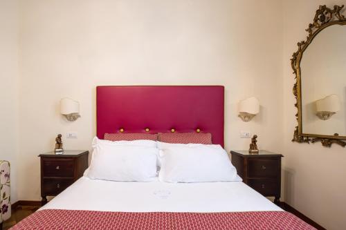 a bedroom with a large bed with a purple headboard at Palazzo Marziale in Sorrento