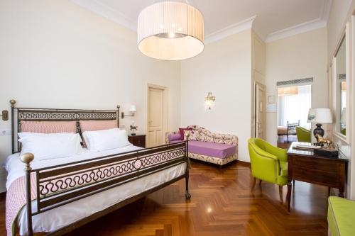 a bedroom with a bed and a desk and a chair at Palazzo Marziale in Sorrento