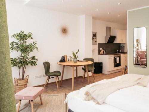 - une chambre avec un lit, une table et des chaises dans l'établissement Brunnen Apartments, à Nuremberg