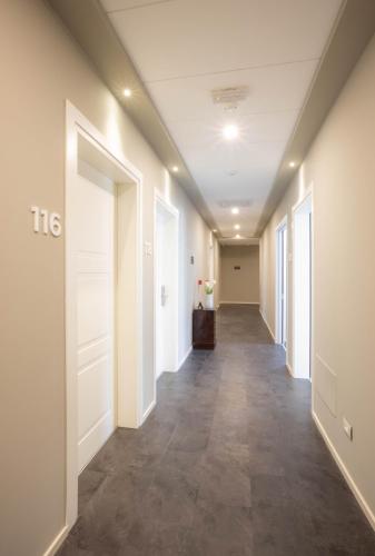 a hallway of an office with white walls and tile floors at V Hotel in Ancona