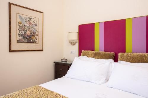 a bedroom with two beds and a painting on the wall at Palazzo Marziale in Sorrento