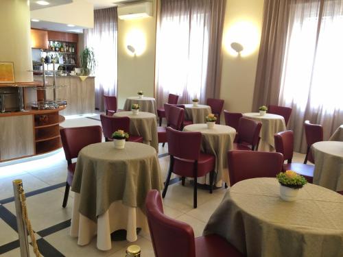 a dining room with tables and chairs and tablesktop at Hotel Arcobaleno in Vimodrone