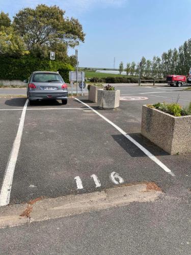 a car is parked in a parking lot at Appartement vue mer in La Guérinière