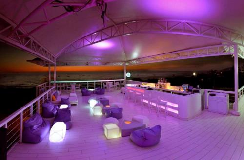 a deck with purple chairs and a bar with purple lights at The Park Calangute Goa in Calangute