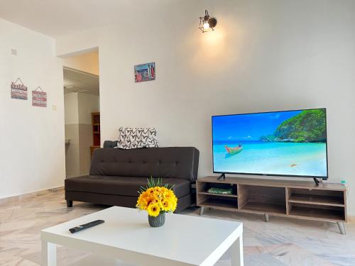 a living room with a couch and a flat screen tv at BayView Suites Port Dickson By MAISON in Port Dickson