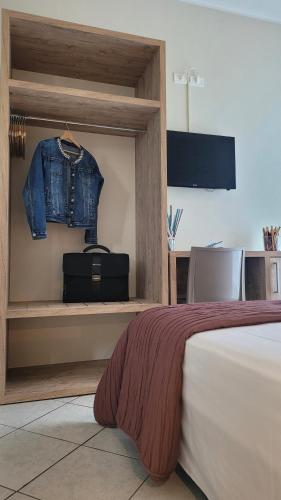 a bedroom with a bed and a denim jacket on a shelf at Hotel Adigrat in Riccione